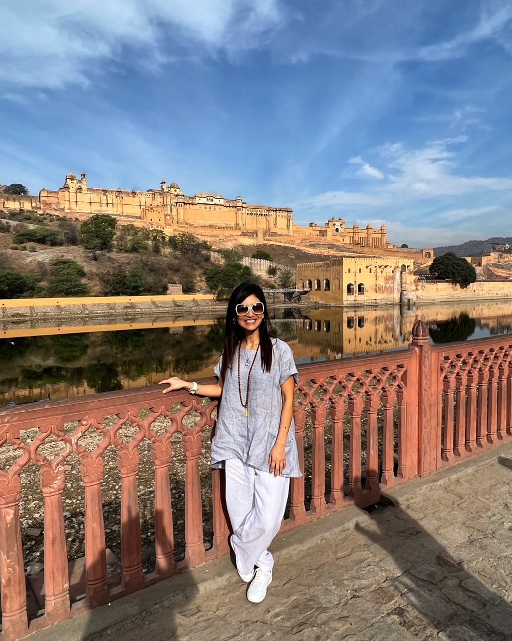 Traveler smiling in front of Amber Fort in Jaipur, India