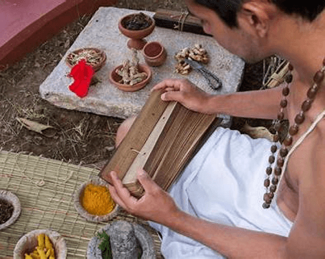 Traditional practitioner with palm-leaf manuscript and Ayurvedic herbs