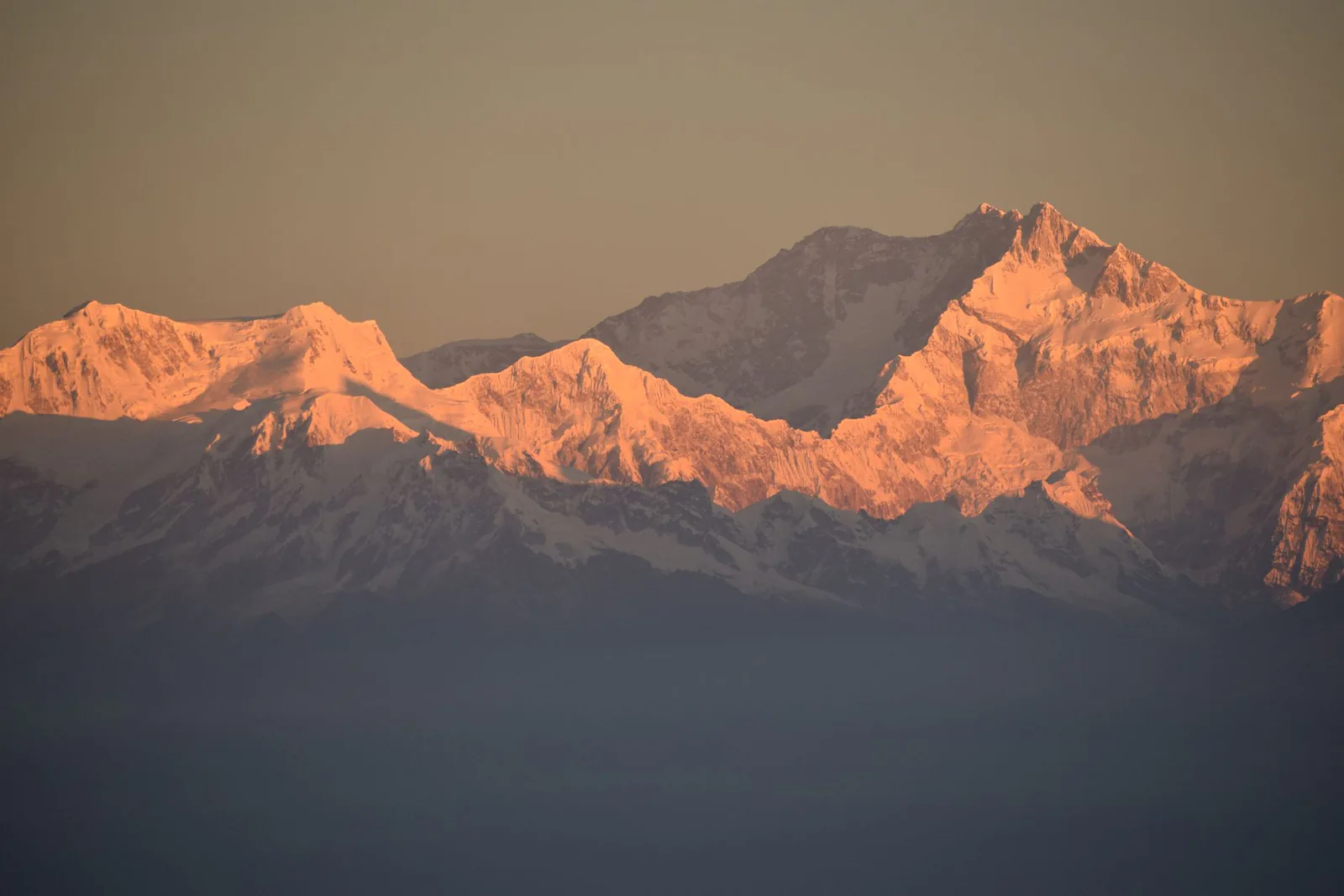 Spectacular snow-covered Himalayan mountain peaks illuminated by golden sunrise light over Uttarakhand, India