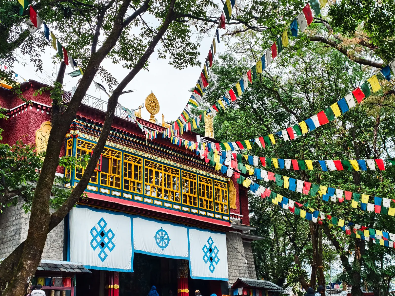 Tibetan monastery with prayer flags beneath the Dhauladhar mountains