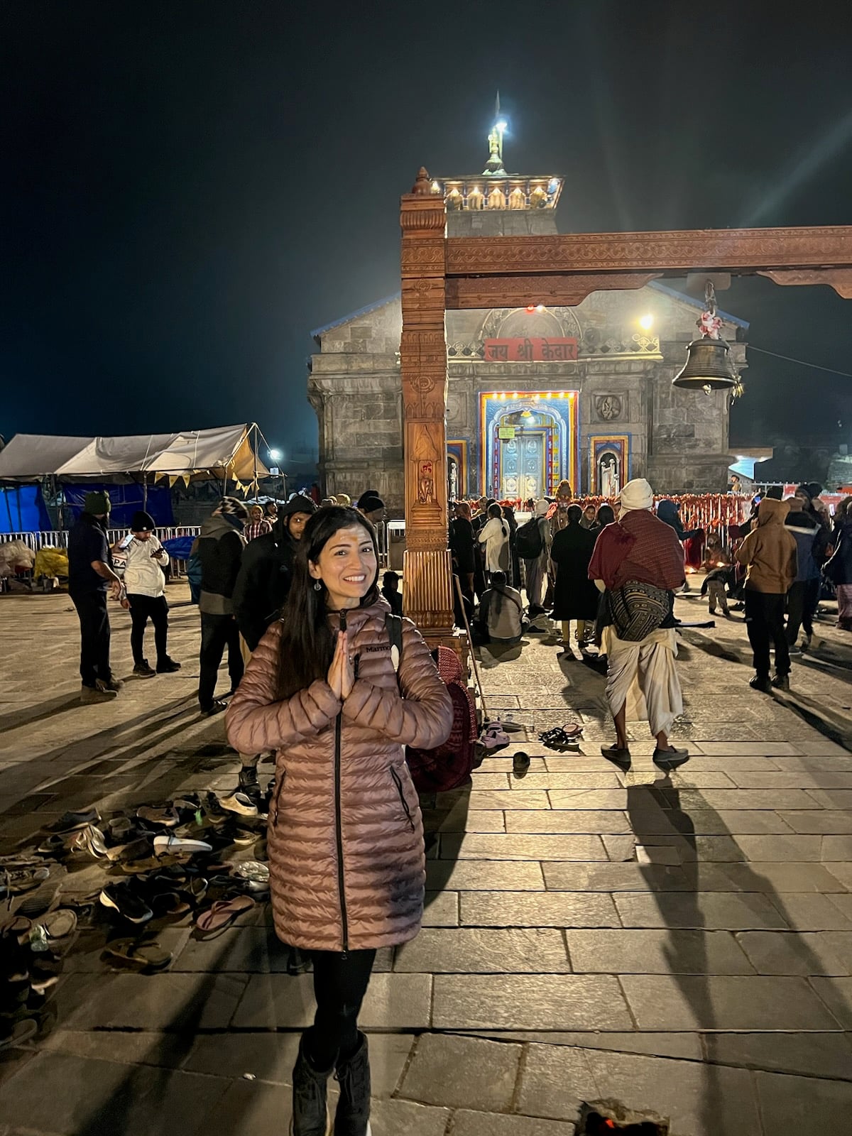 The founder of Soul India Journeys standing in prayer in front of Kedarnath Temple at night.