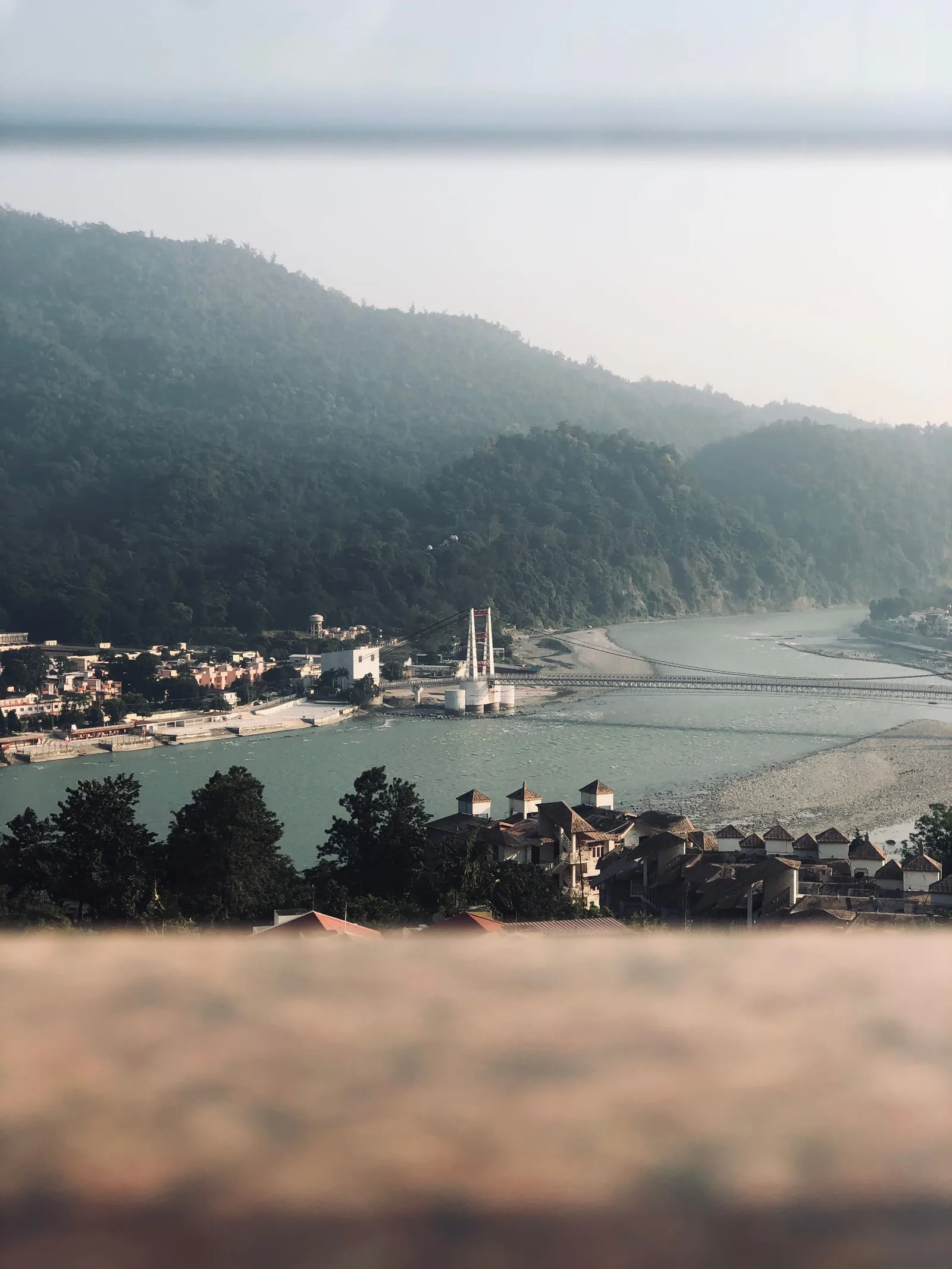 The Ganges flowing through Rishikesh with the Himalayan foothills beyond