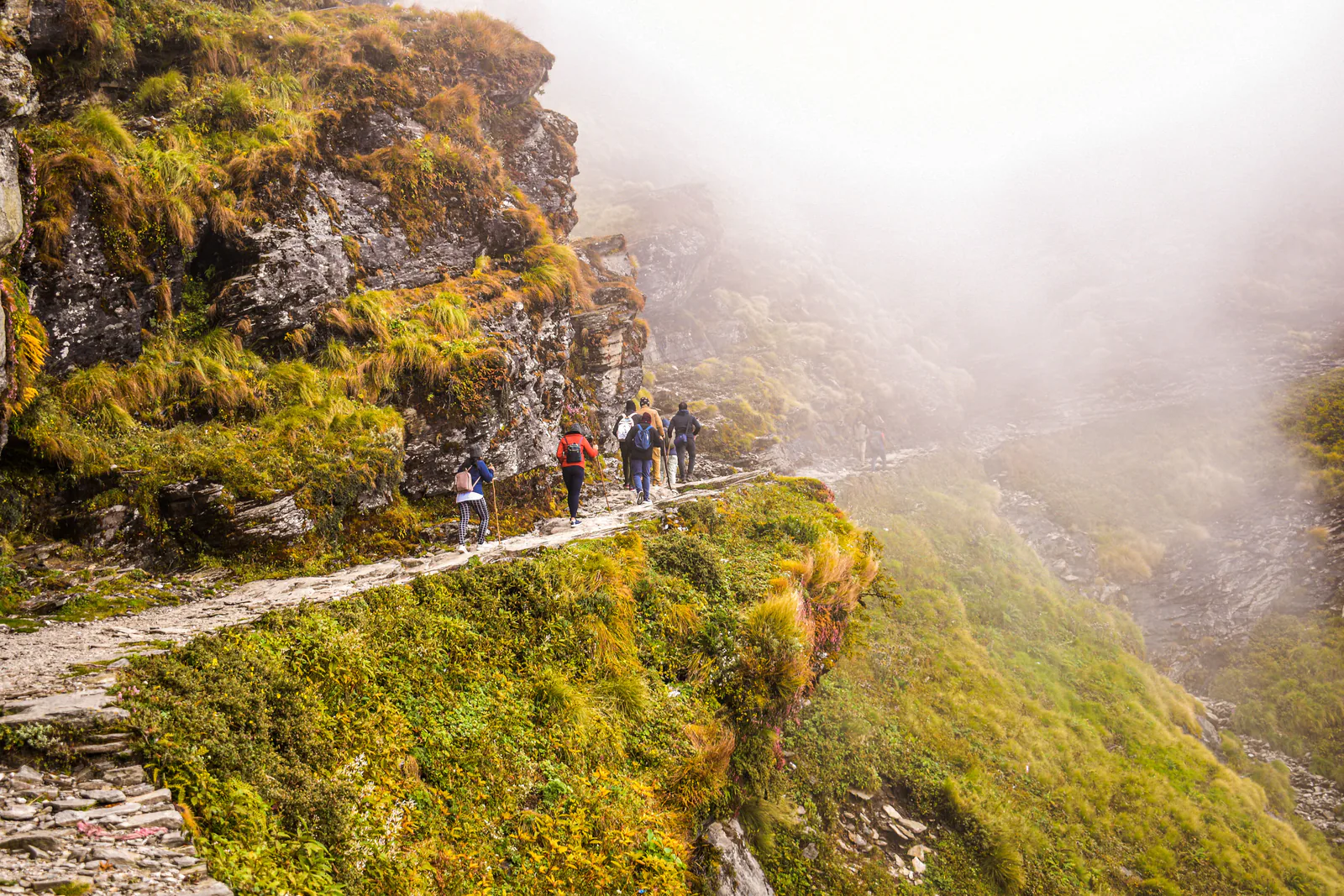 Travelers walking a mountain trail toward Tungnath