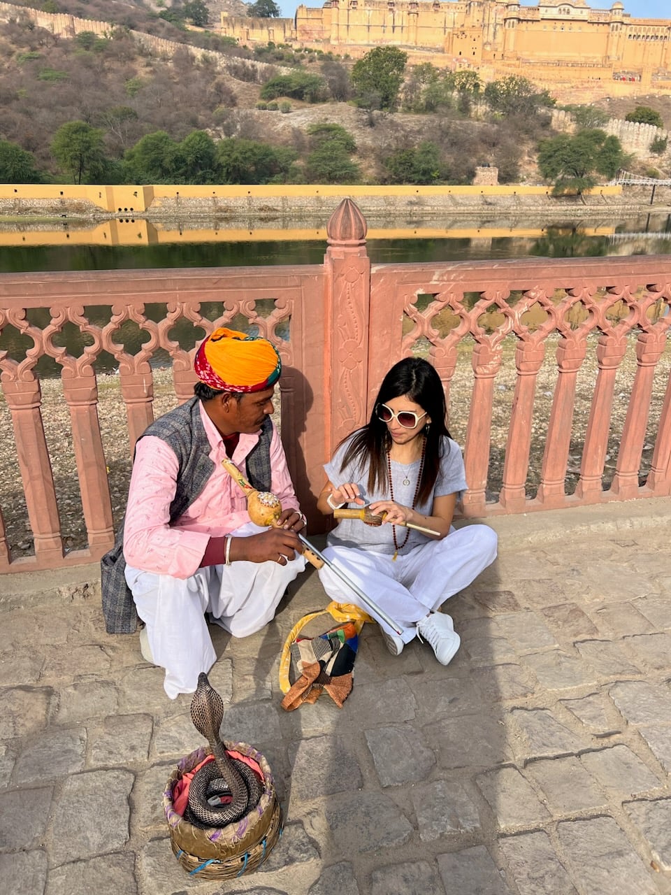 Traveler with a snake charmer during a cultural experience in Jaipur