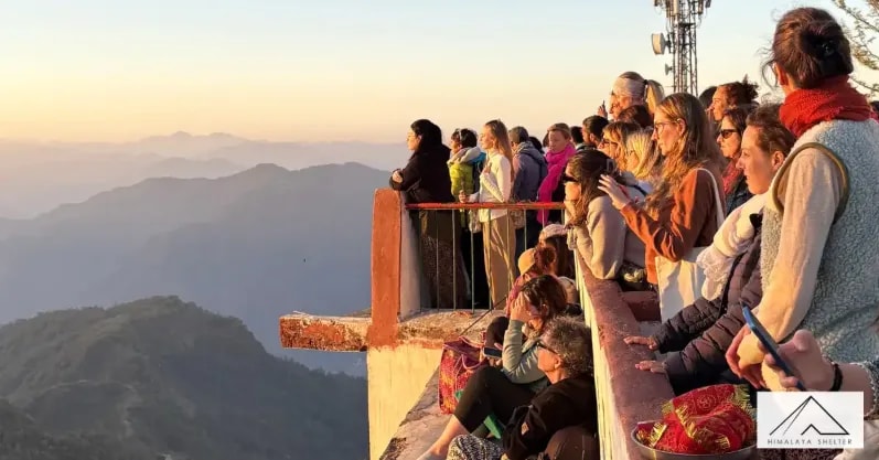 Travelers watching the sunset over the Himalayan foothills from Kunjapuri